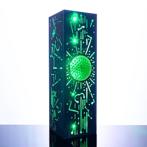 May include: A tall, rectangular black pillar lamp featuring intricate, laser-cut geometric patterns and lines that emit a bright green light. The design includes a central circular motif surrounded by linear elements, creating a glowing, tech-inspired aesthetic.