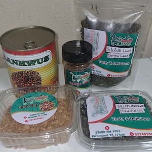 Op de afbeelding: Een assortiment voedingsproducten, waaronder een blik met het label "ANKWUS", een pot "RANGA SPICE" en bakjes met "CRAYFISH", "Bebtete Leaves" en "GEDROOGDE PERIWINKLES". De producten zijn verpakt met labels met de tekst "Tasty & Delicious".