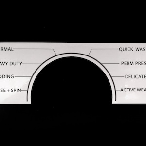 May include: A white appliance control panel with a black arched design and text labels. The labels include "Normal," "Heavy Duty," "Bedding," "Rinse + Spin," "Quick Wash," "Perm Press," "Delicates," and "Active Wear."