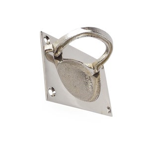 May include: A polished silver door pull with a rounded rectangular base and a curved handle.