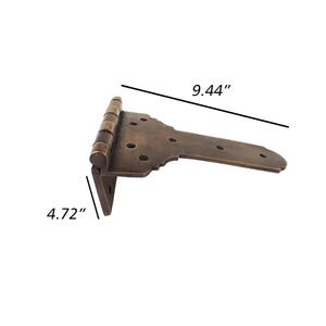 May include: A bronze-colored T-hinge, measuring 9.44 inches long and 4.72 inches wide. The hinge features a decorative shape with multiple screw holes for mounting. The metal has a slightly aged appearance.