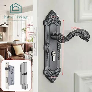 Könnte beinhalten: Ein matt-schwarzer Türgriff mit verzierter, länglicher Rosette und geschwungenem Hebel. Das Set enthält einen silberfarbenen Schließzylinder und einen Einsteckschloss-Mechanismus. Die Maße betragen 160 mm, 85 mm und 175 mm für den Griff.