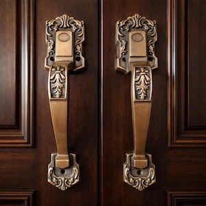 May include: Two antique bronze door handles with ornate floral and scrollwork designs. The handles are mounted on a dark brown wooden door. The handles have a rectangular backplate with a central oval detail and a long, curved handle.