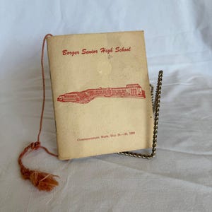 Könnte beinhalten: Ein Vintage-Abschluss-Programm der Borger Senior High School vom 24. bis 28. Mai 1959. Das Cover ist beige mit rotem Text und einer Illustration eines Schulgebäudes. Eine braune Quaste ist am Programm befestigt.
