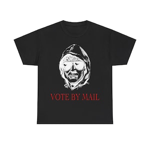 May include: Black t-shirt with a white graphic of a person wearing a hooded sweatshirt and sunglasses. The text "VOTE BY MAIL" is printed in red below the graphic.