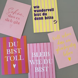 Könnte beinhalten: Fünf farbenfrohe Grußkarten mit deutschem Text. Die Karten weisen verschiedene Designs auf, darunter vertikale Streifen und handgeschriebene Schriftarten. Die Farbpalette umfasst Rosa, Gelb, Orange und Lila. Jede Karte hat eine einzigartige Botschaft.