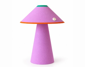 Op de afbeelding: Een tafellamp met een conische voet en een brede, paddenstoelvormige kap, beide in een getextureerde lavendelkleurige afwerking. De kap heeft een felgroen accent aan de bovenkant, een oranje rand en een kleine witte knop.