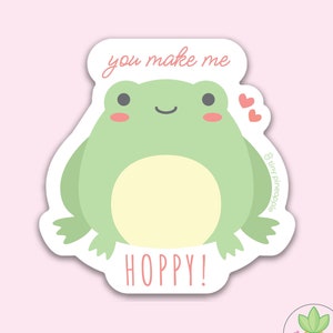 May include: A green frog with a big smile and pink cheeks says "you make me hoppy!" in a pink heart-shaped sticker.