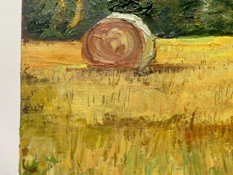 May include: An impressionistic painting of a rural landscape. A large, brown hay bale sits in a field of yellow and green grass. Dark green trees are in the background. The painting uses thick brushstrokes and a warm color palette.