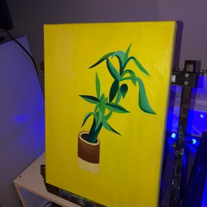 Peut inclure: Une peinture d'une plante verte dans un pot brun et blanc sur un fond jaune.