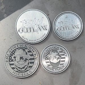 Left: 1.5” flat edge aluminum engraved coin 
Right: 1.25” ridged edge aluminum engraved coin