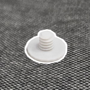 Op de afbeelding: Een witte kunststof schroef met een ronde kop en een schroefdraadas. De schroef heeft een witte omtrek en staat tegen een grijze, getextureerde achtergrond. De schroef is een bevestigingsmiddel.