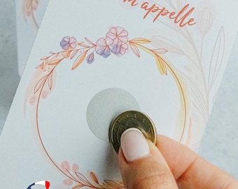 Peut inclure: Une carte blanche avec un motif floral et le texte "Je m'appelle" en français. Une pièce de monnaie est placée sur un cercle sur la carte.