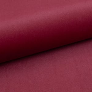 May include: A close-up of a deep burgundy fabric with a soft, velvety texture.