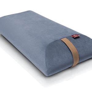 May include: A blue and brown lumbar support pillow with a brown strap and a red label that says "The Pillow Guy".