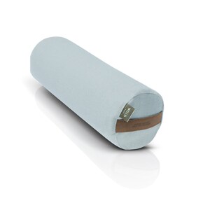 May include: A light blue cylindrical yoga bolster with a brown leather strap and a green label that says "Wild" on it.