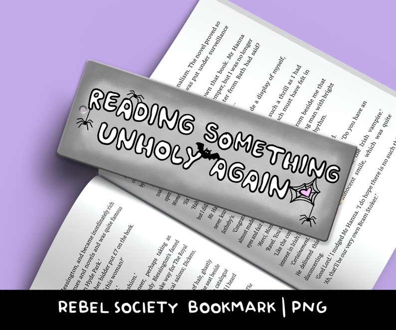 K&ouml;nnte beinhalten: Ein silbernes Lesezeichen mit einer Schwarzwei&szlig;illustration eines Spinnennetzes, einer Fledermaus und dem Text "Reading Something Unholy Again".