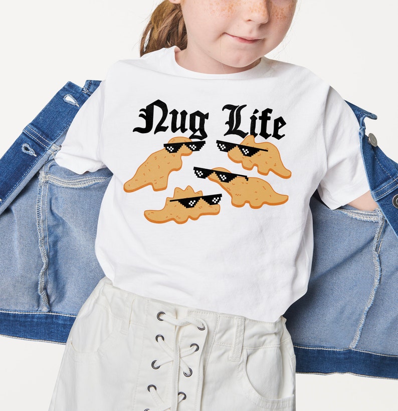 May include: White t-shirt with a black graphic that says "Nug Life" and features cartoon chicken nuggets wearing sunglasses.