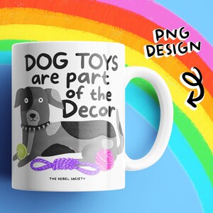 May include: White ceramic mug with a dog illustration and the text "DOG TOYS are part of the Decor". The dog is black and white with a green ball, pink yarn ball, and purple rope toy. The mug has a white handle and the words "PNG DESIGN" are in the top right corner.