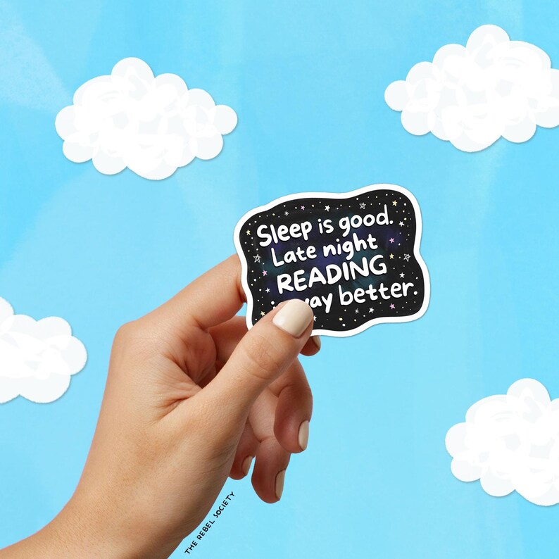 Pu&ograve; includere: Un adesivo nero con testo bianco che recita "Sleep is good. Late night READING way better". L'adesivo ha un design a notte stellata ed &egrave; tenuto su uno sfondo di cielo blu con ritagli di nuvole bianche.