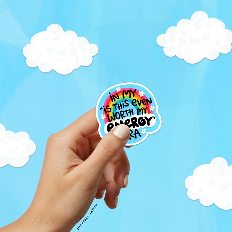 K&ouml;nnte beinhalten: Ein runder Aufkleber mit hellblauem Hintergrund, einem bunten Regenbogen und kleinen wei&szlig;en Blumen. Der Text lautet: IN MY "IS THIS EVEN WORTH MY ENERGY" ERA. Der Aufkleber hat einen wei&szlig;en Rand und wird vor einem blauen Himmel pr&auml;sentiert.