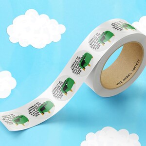 May include: A roll of white, round stickers with a cartoon image of a green chair and the text "Literally me watching the fall of democracy play out in real time." The roll has a brown cardboard core and the text "The Rebel Society."