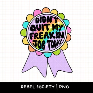 May include: A colorful badge-shaped graphic with the text "DIDN'T QUIT MY FREAKIN JOB TODAY". The badge has a rainbow-colored center, a scalloped edge, and a lavender ribbon. The text is in a bold, playful font.