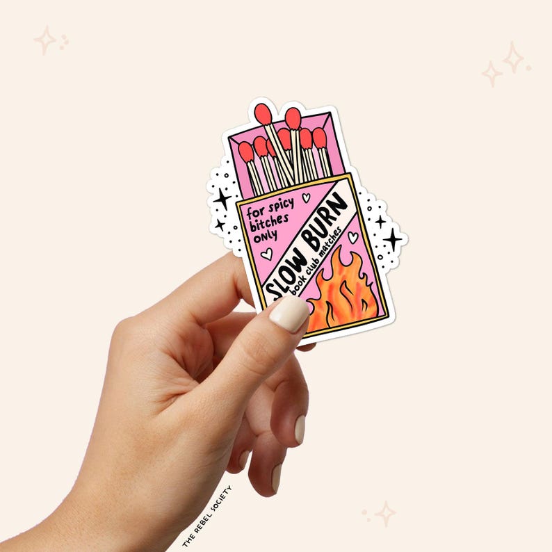 Puede incluir: Una pegatina rosa y blanca con una caja de cerillas que dice "Slow Burn Book Club Matches" y "For Spicy Bitches Only".