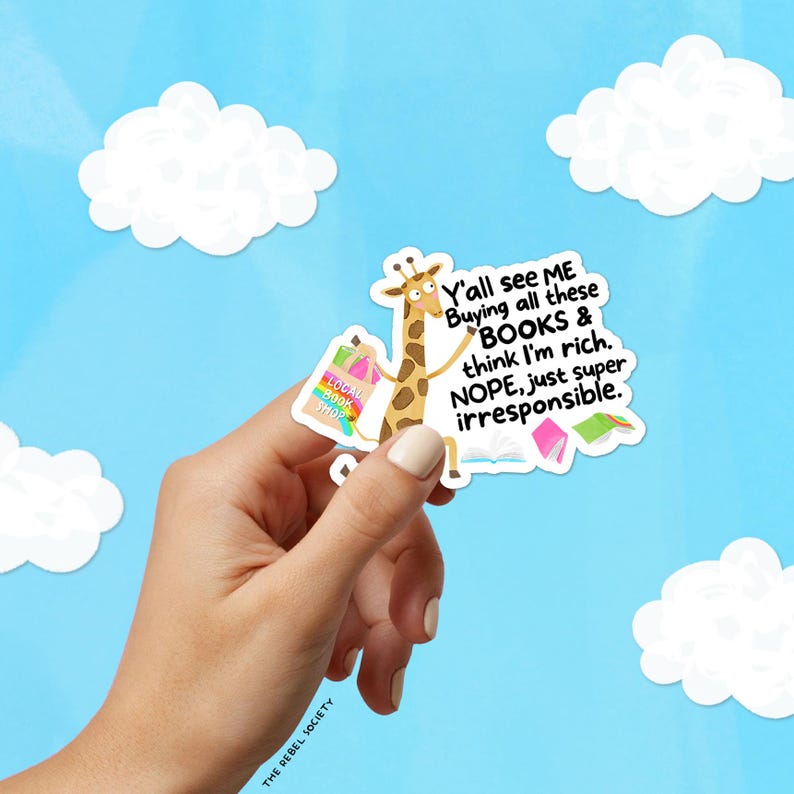 May include: A sticker featuring a giraffe with shopping bags from a "Local Book Shop" and the text "Y'all see ME Buying all these BOOKS & think I'm rich. NOPE, just super irresponsible." The sticker is held against a blue sky with white clouds.