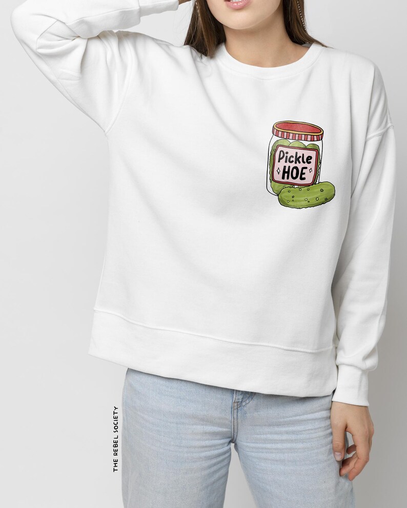 May include: White sweatshirt with a cartoon illustration of a pickle jar with the text "Pickle Hoe" on the front.