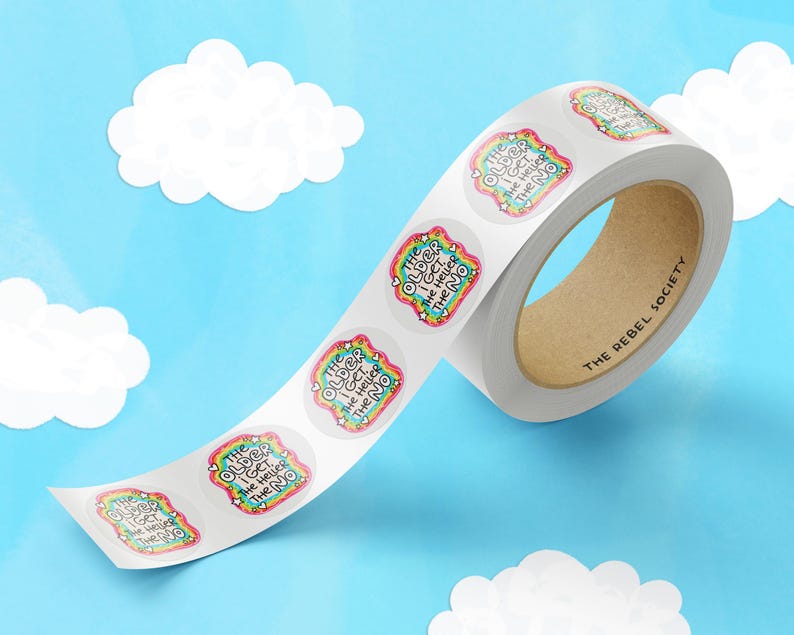 May include: A roll of circular adhesive stickers featuring a colorful, rainbow-patterned border and the text THE OLDER I GET, THE HELLIER THE NO. The stickers are arranged in a continuous strip on a white backing, with a brown cardboard core.