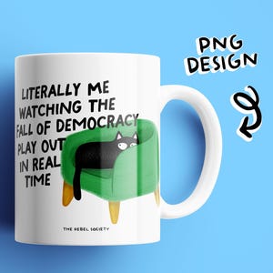 May include: White ceramic mug with a black cat illustration on a green chair. The mug features the text "Literally me watching the fall of democracy play out in real time." The words "PNG Design" are also visible.