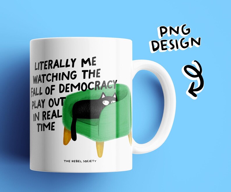 May include: White ceramic mug with a black cat illustration on a green chair. The mug features the text "Literally me watching the fall of democracy play out in real time." The words "PNG Design" are also visible.