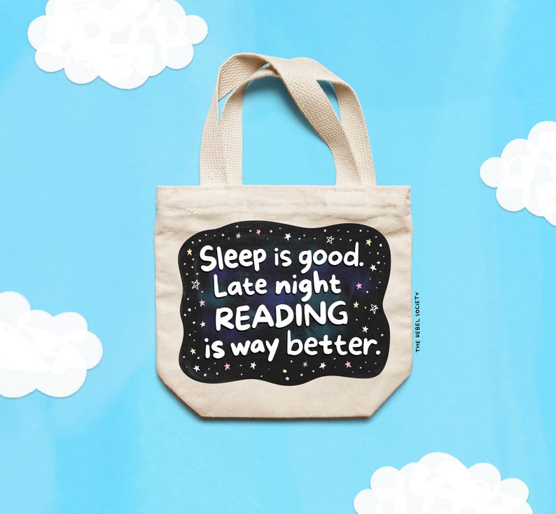 Pu&ograve; includere: Una borsa tote beige con la scritta "Sleep is good. Late night READING is way better." in un design in bianco e nero. La borsa ha due manici ed &egrave; ambientata su uno sfondo blu con ritagli di nuvole bianche.
