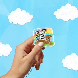 May include: A colorful sticker featuring a brown dog lying on green grass with a rainbow and sun graphic. The text reads, "I CAN'T STAY TOO LONG. MY DOG IS WAITING FOR ME." The sticker is held against a blue sky background with white cloud cutouts.