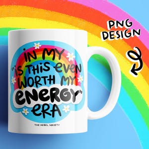 K&ouml;nnte beinhalten: Ein wei&szlig;er Keramikbecher mit einer bunten Grafik aus Regenbogen, blauem Himmel und wei&szlig;en Blumen. Der Text lautet: IN MY "IS THIS EVEN WORTH MY ENERGY" ERA. Unter dem Text stehen die Worte THE REBEL SOCIETY in kleinen schwarzen Buchstaben.