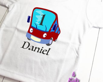 May include: White t-shirt featuring a red bus graphic, with the number "1" on the windscreen and the name "Daniel" printed below.