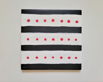 Schwarzweiße Streifen mit roten Punkten auf einer 10 x 10 cm großen Fliese