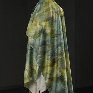 Puede incluir: Una tela drapeada con un patr&oacute;n similar a la acuarela en tonos verdes, azules y amarillos. La tela est&aacute; drapeada sobre una forma invisible, creando pliegues suaves y una apariencia fluida. El efecto general es art&iacute;stico y et&eacute;reo.