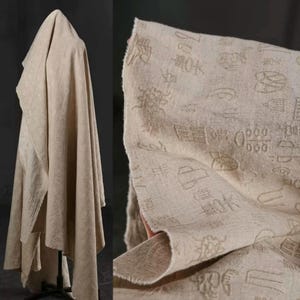 May include: Beige linen fabric featuring a delicate pattern of Asian characters. The fabric is draped, revealing its texture and flow. A close-up shows the detailed print and the raw edge of the material, emphasizing its natural appearance and quality.
