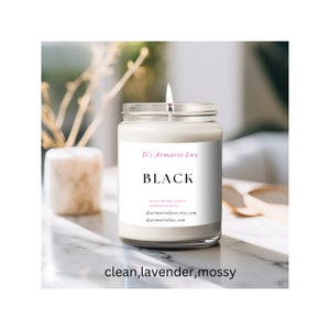 May include: A white candle in a glass jar with a black label that reads "D's Armario Lux" and "BLACK". The label also includes the text "Soy Blend Candle Handmade in PA" and the website address "dsarmarioluxe.etsy.com". The candle is sitting on a white marble surface. The text "clean, lavender, mossy" is written below the candle.