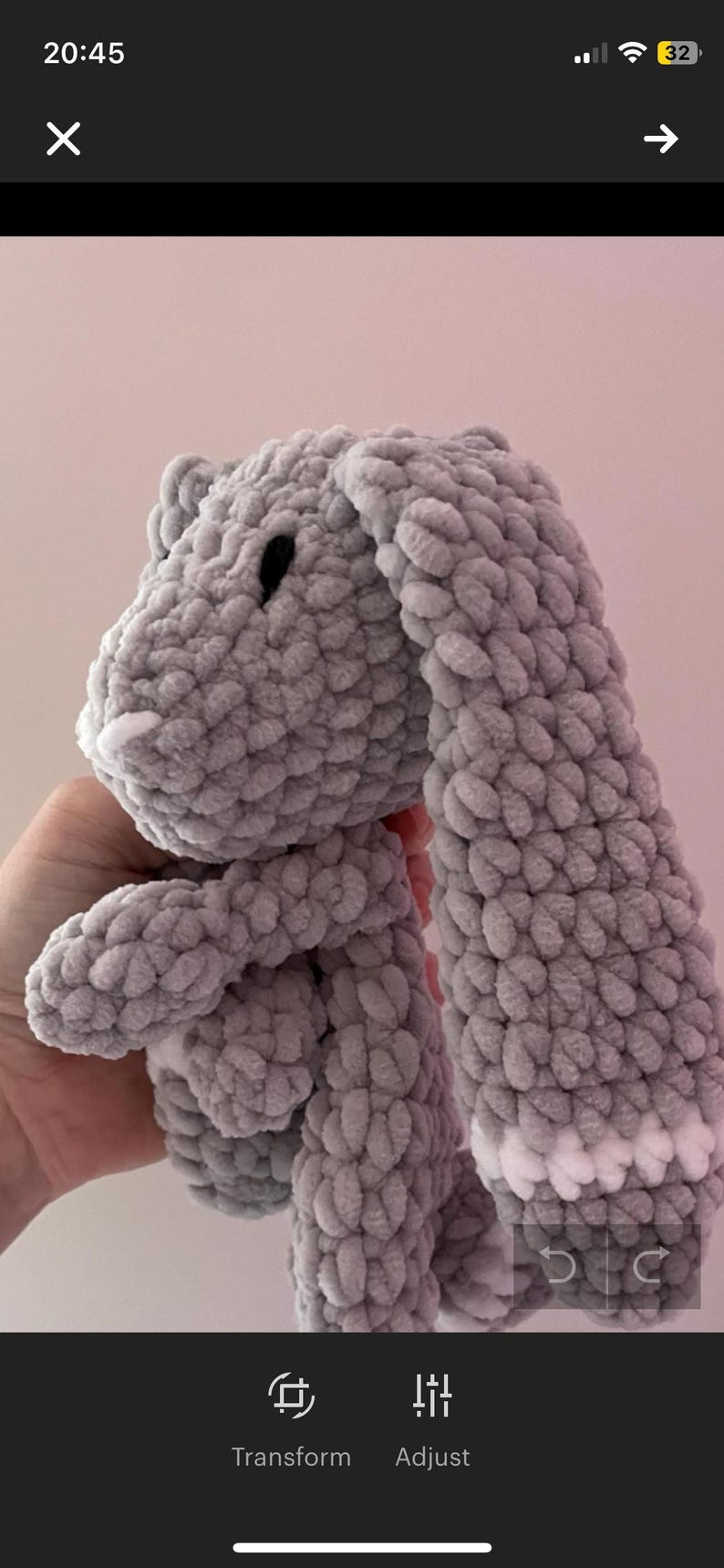 May include: A gray crocheted bunny with white accents on the ears. The bunny is soft and cuddly, perfect for a child's toy.