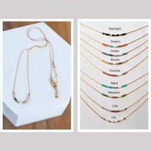 Puede incluir: Una colecci&oacute;n de delicados collares de oro con detalles de cuentas de colores. Cada collar presenta una combinaci&oacute;n de colores diferente y est&aacute; etiquetado con un nombre, como "Midnight", "Tropics", "Ocean" y "Bloom".