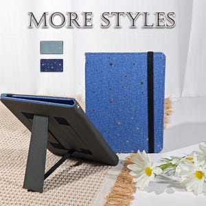 May include: Blue tablet case with a star pattern and a black elastic band. The case is open, revealing a stand. The words "MORE STYLES" are at the top of the image. The case is on a patterned surface.