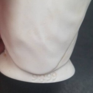May include: White porcelain figurine with a number 999 on the bottom.