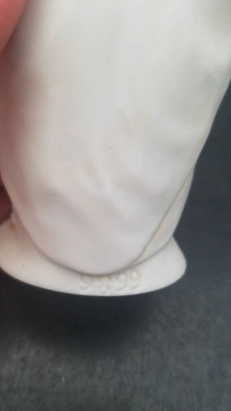 May include: White porcelain figurine with a number 999 on the bottom.