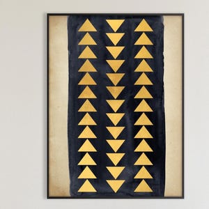 Puede incluir: Obra de arte abstracta enmarcada con fondo azul oscuro y triángulos dorados. La obra cuelga sobre una chimenea en un salón moderno. La habitación incluye muebles blancos y esculturas decorativas.