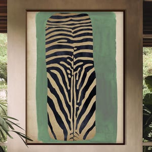 Puede incluir: Obra de arte enmarcada de gran tamaño con un diseño de estampado de cebra en negro y beige sobre un fondo verde apagado. La obra se exhibe en un salón con un sofá de madera, cojines neutros y una mesa de centro de madera. La habitación tiene una estética natural y terrosa.