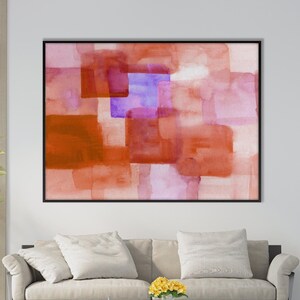 Peut inclure: Peinture abstraite &agrave; l'aquarelle dans un cadre noir. L'&oelig;uvre pr&eacute;sente des carr&eacute;s superpos&eacute;s dans des tons orange, rouge et violet. La peinture est accroch&eacute;e au-dessus d'un canap&eacute; beige dans un salon moderne.