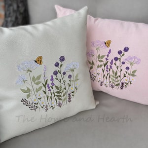 Pode incluir: Duas almofadas bordadas com um design floral. A almofada &agrave; esquerda &eacute; verde claro com uma borboleta amarela. A almofada &agrave; direita &eacute; rosa com uma borboleta amarela.
